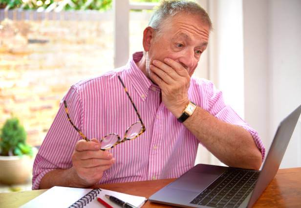 Man looking at his laptop wondering what is buy now pay later.